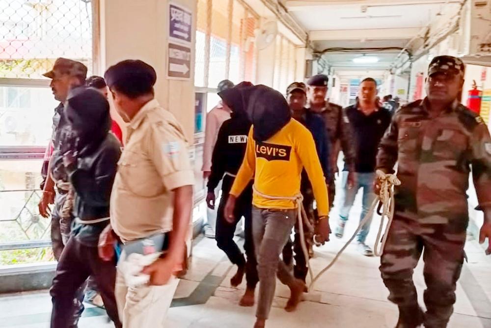 Police personnel escort men accused for allegedly carrying out a brutal assault on a Spanish woman, to a district court in Dumka//AFPix