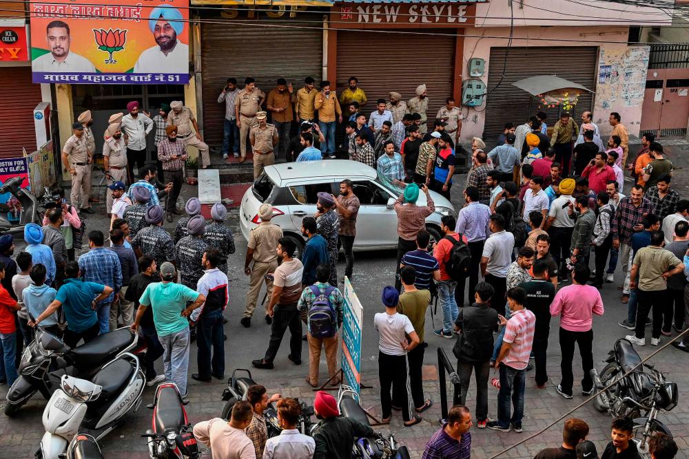 Police and onlookers gather at the site where Shiv Sena leader Sudhir Suri was shot dead while he was protesting in front of a temple by an unidentified assailant in Amritsar on November 4, 2022/AFPPix