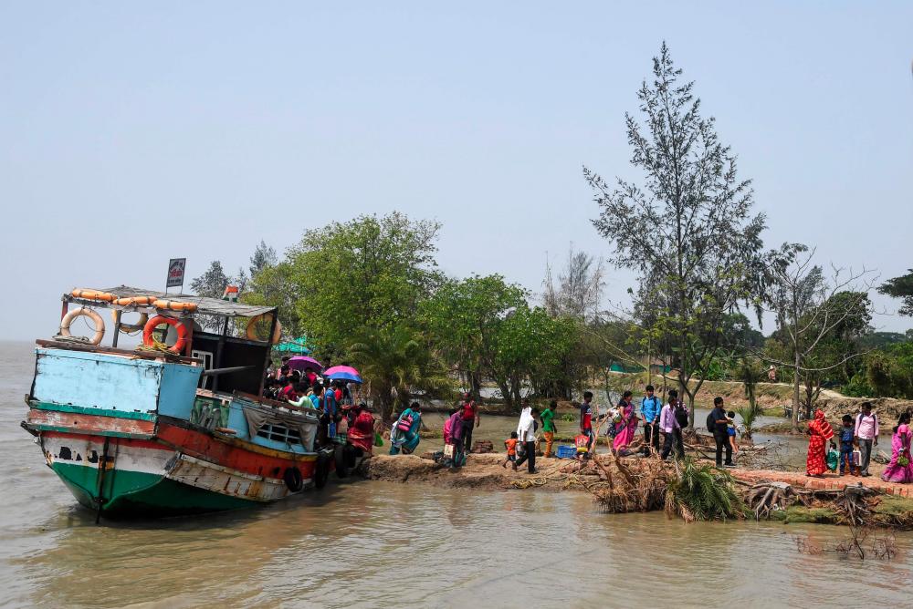 Indian voters arrive with a ferry boat to cast their vote in the Ghoramara island around 110km south of Kolkata on May 19, 2019, during the 7th and final phase of India's general election. — AFP