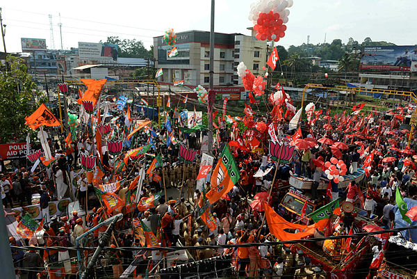 In this photo taken on April 21, 2019 Indian supporters of the Bharatiya Janata Party (BJP), National Congress Party and Communist Party of India celebrate in front of each other during the final day of election campaigning in the city of Pathanamthitta, in the south Indian state of Kerala. — AFP