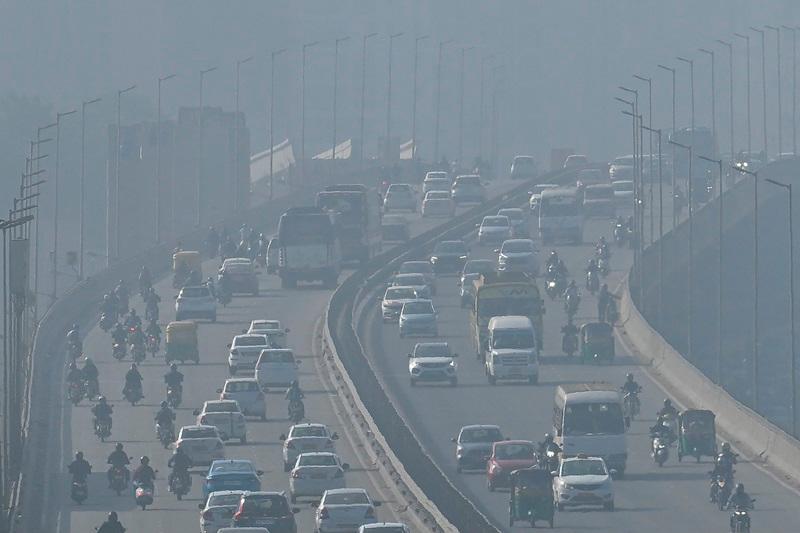 Vehicles move along a bridge on a foggy morning in Bengaluru on November 22, 2024. - IDREES MOHAMMED / AFP