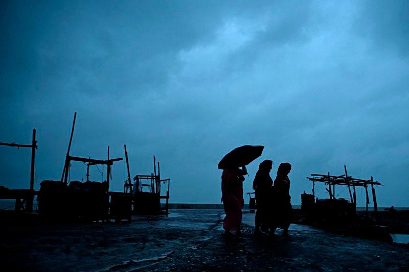 Villagers walk along a beach near Digha on October 24, 2024, as cyclone Dana is likely to hit the coasts of West Bengal and Odisha states. - AFPPIX