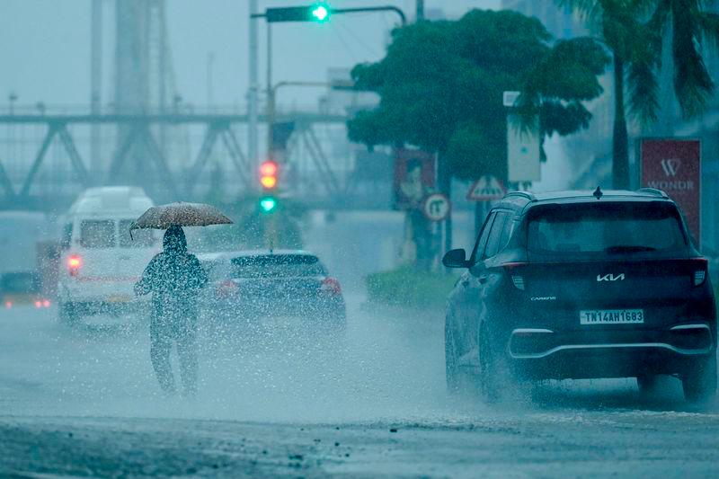 People commute along a street amid heavy rains ahead of a cyclonic storm in Chennai - AFPpix