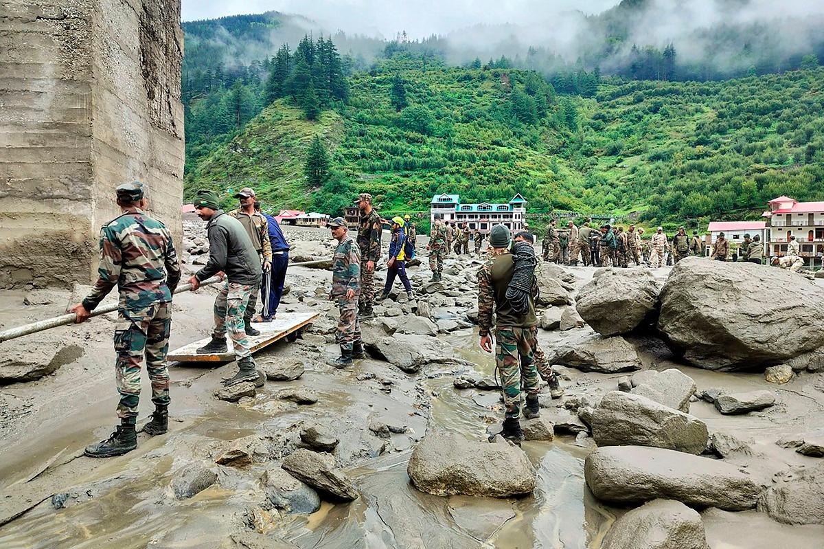 This handout photograph released on August 6, 2025 by the Indian Army shows security and relief personnel building a crossing across a stream of dense sludge during a search and rescue operation, a day after a cloudburst caused a massive mudslide and flash floods in India’s Uttarakhand state. - AFP PHOTO / Indian Army