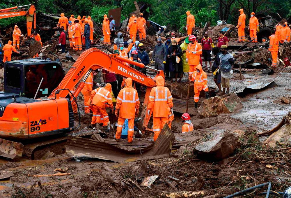 Rescue workers search for missing people at a landslide site caused by heavy rains in Pettimudy, in Kerala state, on August 8, 2020. — AFP