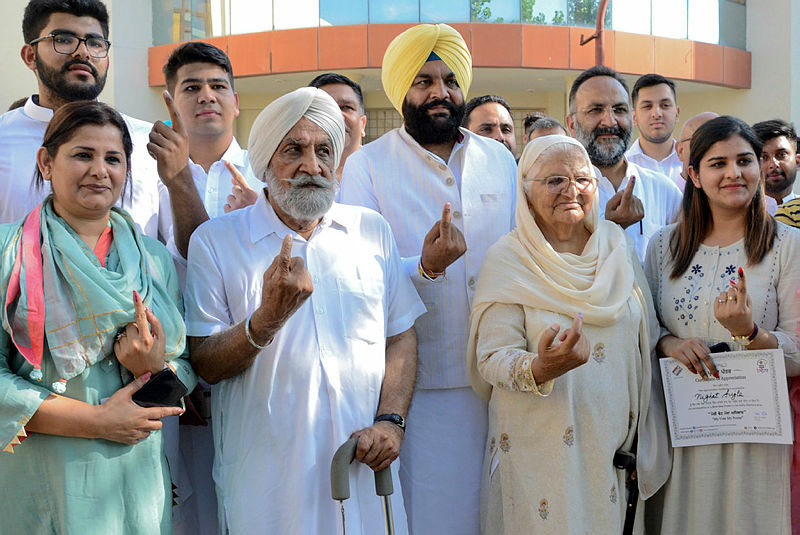 Indian Congress party candidate for Amritsar’s Parliament seat, Gurjeet Singh Aujla (C), along with his father Sarabjit Singh Aujla (2L), his mother Gurmeet Kaur (2R), his wife Undleed Roy Aujla (L), his daughter Nighat Aujla (R), and his son Babar Aujla (L behind) show their ink-marked finger after casting their vote at a polling station in Amritsar on May 19, 2019, during the 7th and final phase of India’s general election. — AFP