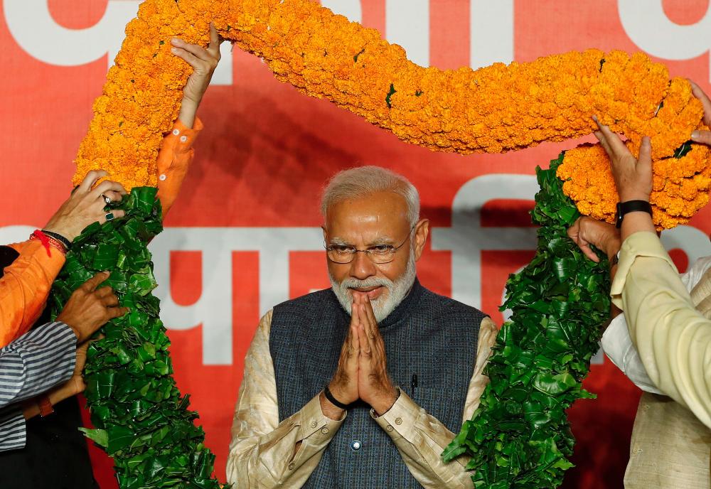 Indian Prime Minister Narendra Modi gestures as he is presented with a garland by Bharatiya Janata Party (BJP) leaders after the election results in New Delhi, India, May 23, 2019. - Reuters
