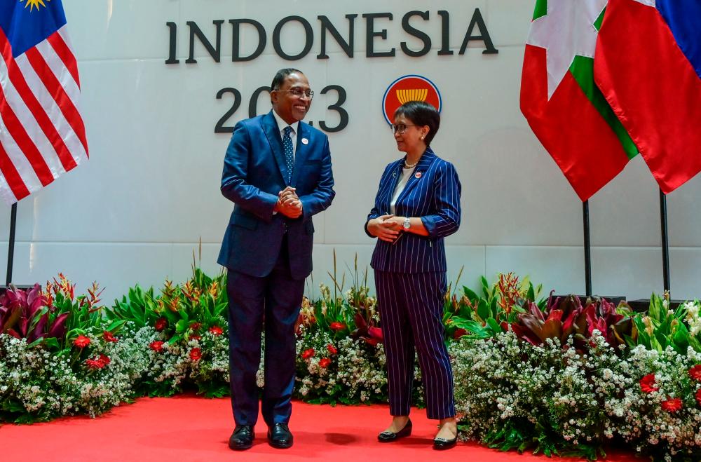 Indonesia's Foreign Minister Rento Marsudi (R) welcomes her Malaysia's counterpart Zambry Abdul Kadir (L) during the 32nd ASEAN Coordinating Council meeting in Jakarta.