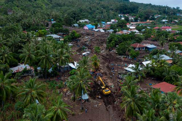 An aerial picture shows an excavator searching for a body at an area affected by landslides triggered by tropical cyclone Seroja in East Flores, East Nusa Tenggara province, Indonesia April 8, 2021. — Antara Foto/Aditya Pradana Putra/via Reuters.