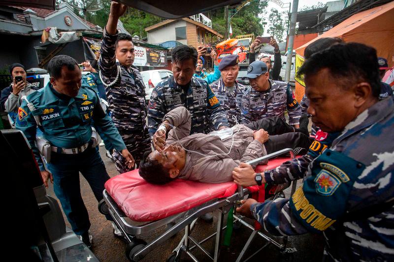 Rescue personnel transport a survivor, from the site of a landslide triggered by heavy rains, to a hospital in Mudal village, near Pekalongan city in Central Java - AFPpix