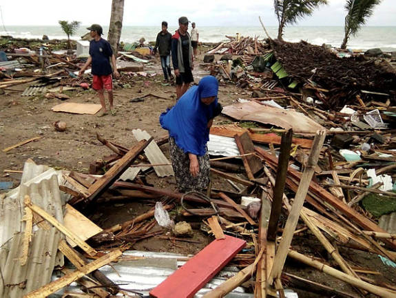 Residents inspect the damage to their homes on Carita beach on Dec 23, 2018, after the area was hit by a tsunami on December 22 that may have been caused by the Anak Krakatoa volcano. — AFP