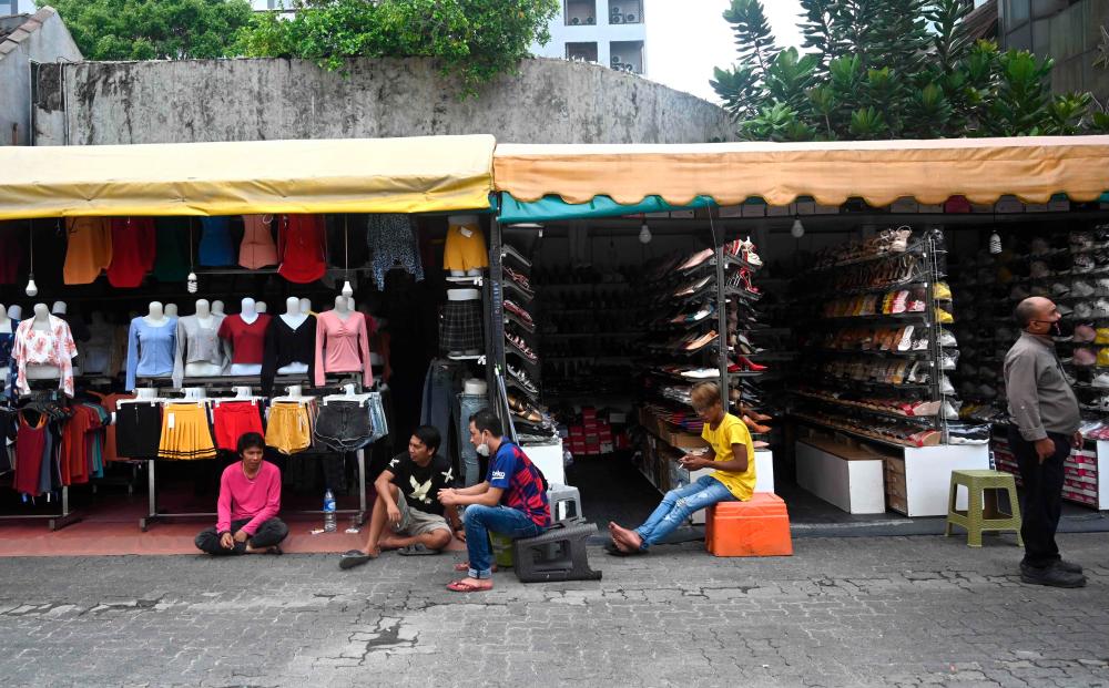 Traders waiting for customers in Jakarta on Monday. as Indonesia’s economy contracted in 2020 for the first time in more than two decades as Covid-19 crippled business activities. – AFPPIX