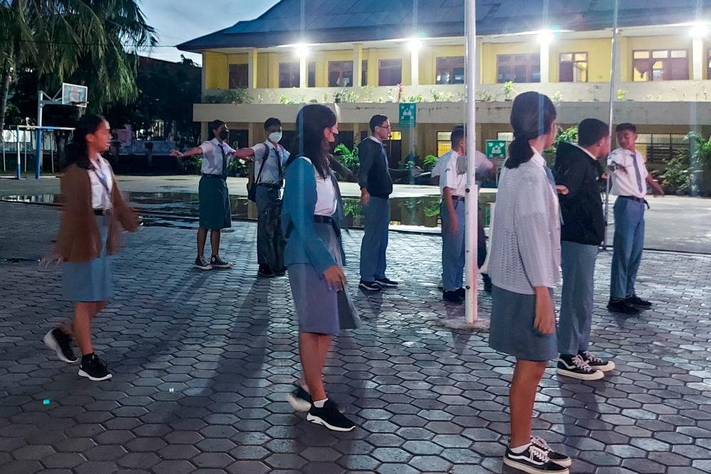 This picture taken on March 6, 2023 shows high school students gathering for the roll call on campus early in the morning in Kupang. A pilot project in Kupang, the capital of East Nusa Tenggara province, has twelfth-graders at 10 high schools starting classes at 5:30 am. AFPPIX