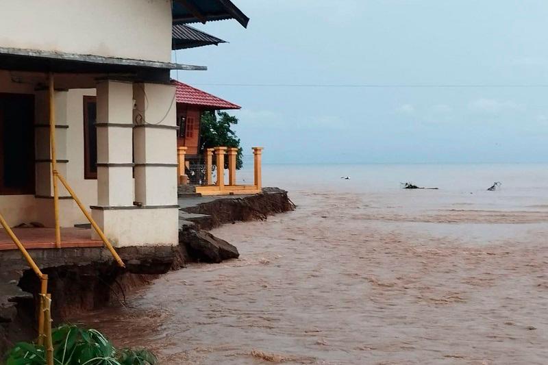 This handout picture taken and released by the Regional Disaster Management Agency (BPBD) Bone Bolango Regency on July 7, 2024, shows erosion from floods threatening residential buildings following heavy rain in Bone Bolango regency, Gorontalo province. Indonesia is in the dry season but torrential rains battered some regions in the past view days, causing flooding in some areas including a landslide that struck a traditional gold mine in Bone Bolango regency where five were killed and 26 others reported missing. -