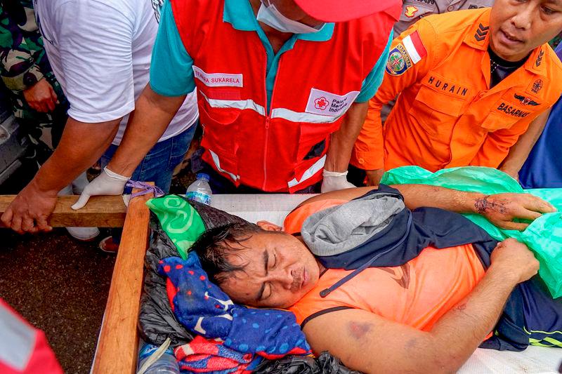 Members of a rescue team carry a survivor of the landslide at Tulabolo village in Bone Bolango Regency of the Gorontalo Province - AFPpix