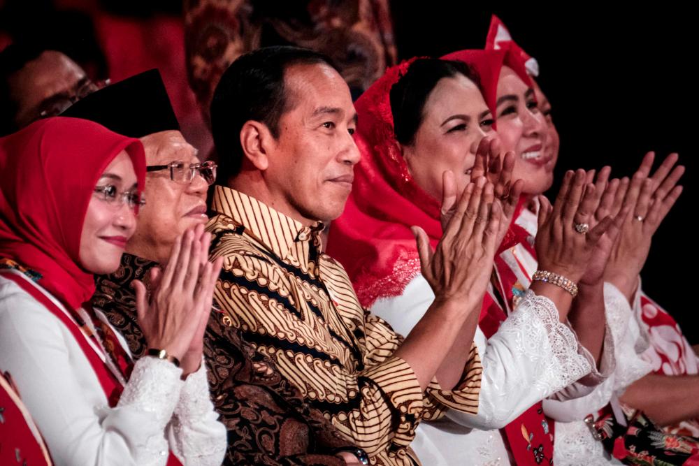 Indonesian President Joko Widodo (C) react before players of Indonesia's traditional bamboo musical instruments angklung achieve the new Guinness World Record for the largest angklung ensemble by 15110 players as a pre-ceremony event for the 78th Anniversary of Indonesia's independence at the Gelora Bung Karno Stadium in Jakarta on August 5, 2023. - AFPPIX