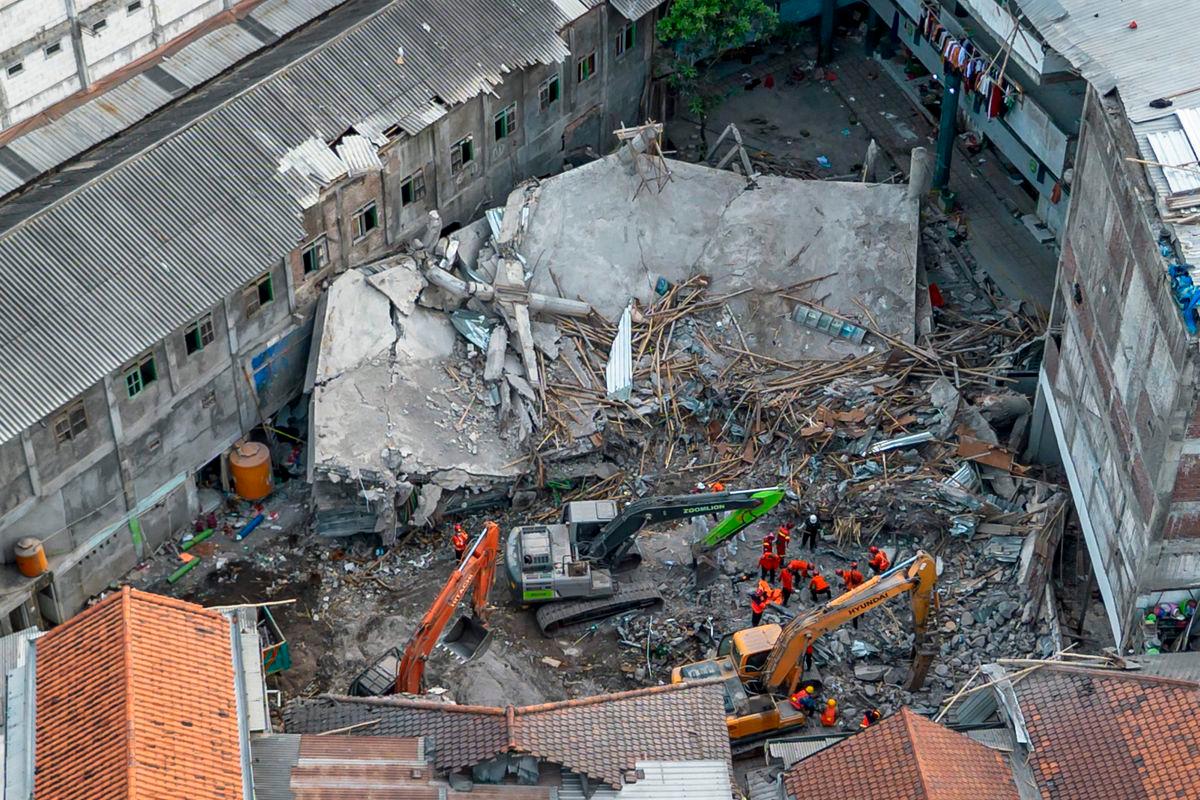 An aerial view shows rescuers searching for victims at the Al Khoziny Islamic boarding school in Sidoarjo, East Java, on October 5, 2025, after a multi-story building at the school collapsed during prayers, killing at least 37 people, with 26 others still missing, according to an official. (Photo by Dicky Bisinglasi / AFP)