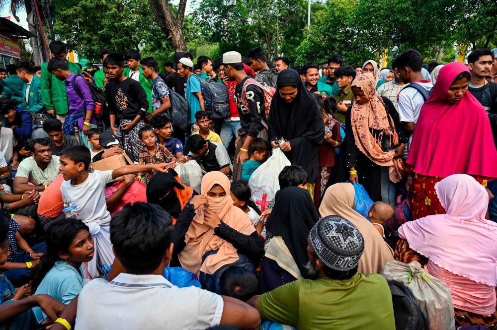 Rohingya refugees gather in front of a government building after demonstrating university students forced them to relocate from a previous government facility, in Banda Aceh on December 27, 2023/AFPpix