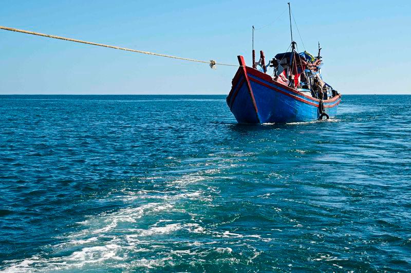 A boat with Rohingya refugees is pulled by a relief vessel to anchor closer to shore off the coast of Labuhan Haji in Southern Aceh province on October 21, 2024. AFPPIX