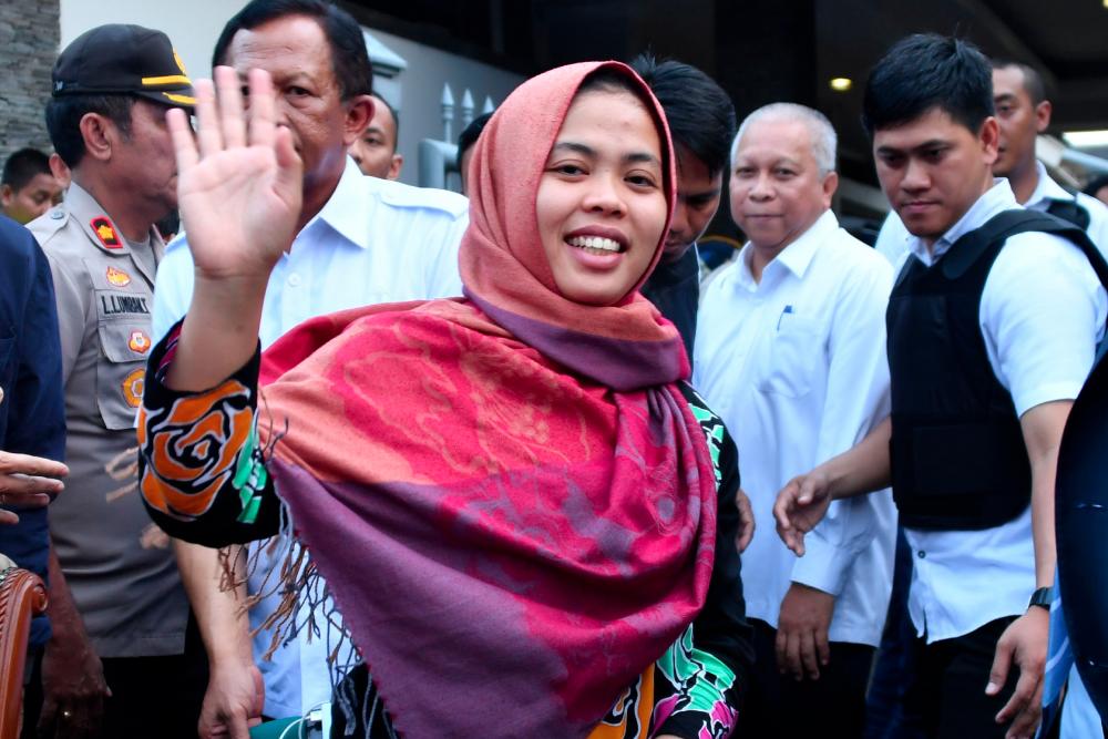 Indonesian Siti Aisyah waves after a press conference in Jakarta on March 11, 2019.— AFP