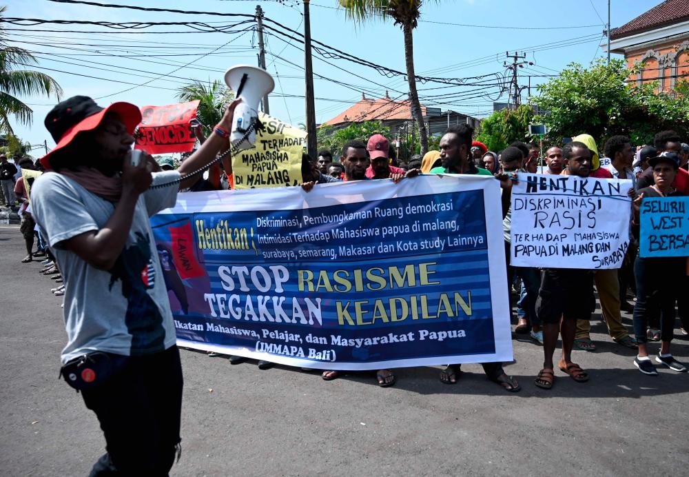 People hold banners and placards against the recent surge in violent protests in Indonesia's eastern Papua province, at a rally in Denpasar on Indonesia’s resort island of Bali on August 22, 2019. - AFP