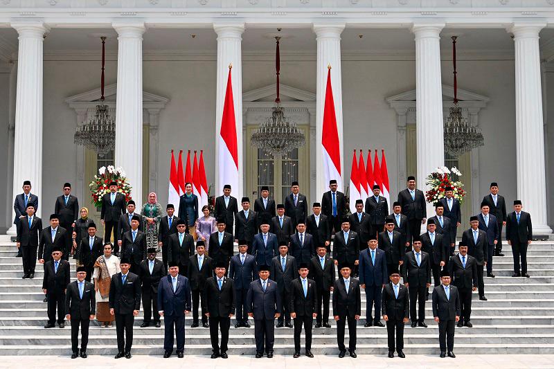 Indonesia's President Prabowo Subianto (front centre L) and Vice President Gibran Rakabuming Raka (front centre R) pose with newly sworn-in cabinet ministers in front of the Presidential Palace in Jakarta on October 21, 2024. - BAY ISMOYO / AFP