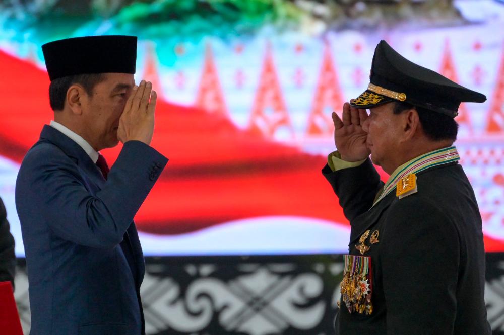 President Joko Widodo (C) awards the honorary four-star general to Defence Minister Prabowo Subianto (R) during a meeting with high rank military and police officers at military headquarters in Jakarta on February 28 2024/AFPPix