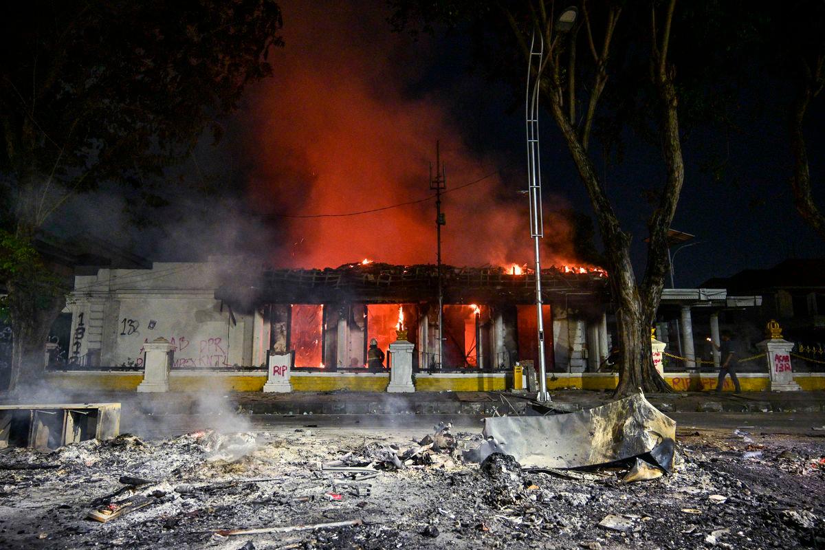 For representational purposes only: A firefighter extinguishes a fire at a government building that was set on fire and looted during demonstrations in Surabaya on August 31, 2025. Southeast Asia’s biggest economy has been rocked by protests in major cities, including the capital Jakarta, since April 29 after footage spread of a motorcycle taxi driver being run over by a police tactical vehicle during an earlier rally against low wages and financial perks for lawmakers. (Photo by Juni KRISWANTO / AFP)