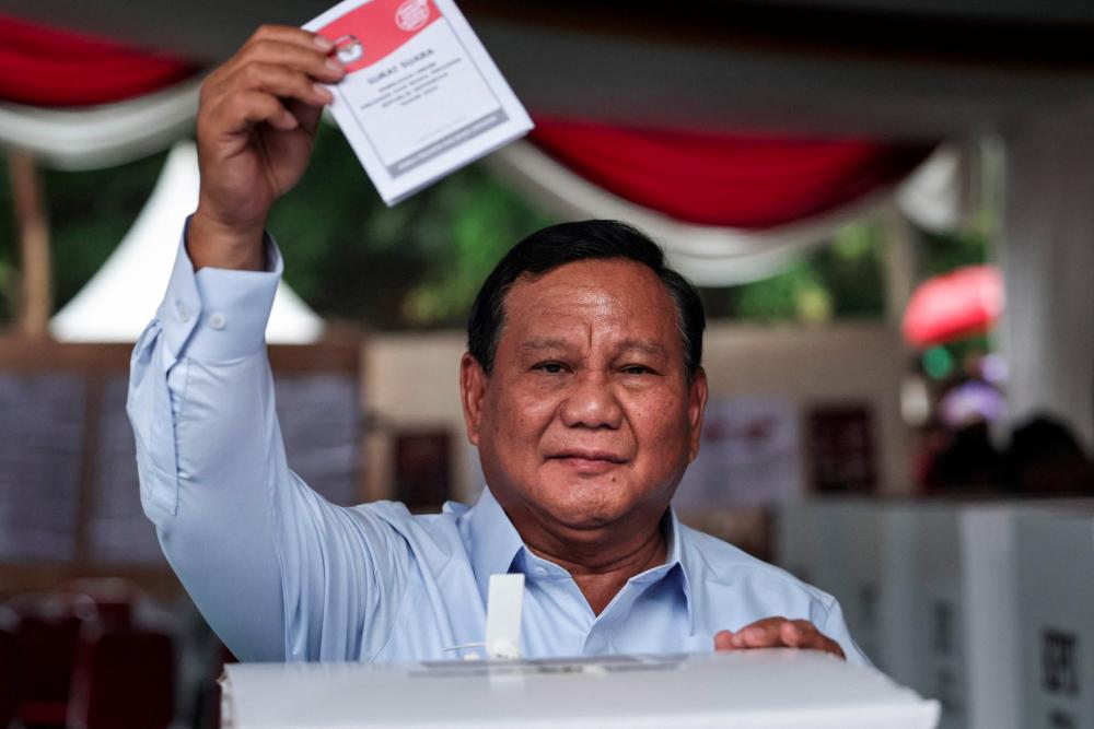 Indonesia's presidential candidate Prabowo Subianto holds up his ballot before voting in the country’s presidential and legislative elections at a polling station in Bogor on February 14, 2024. - AFPPIX