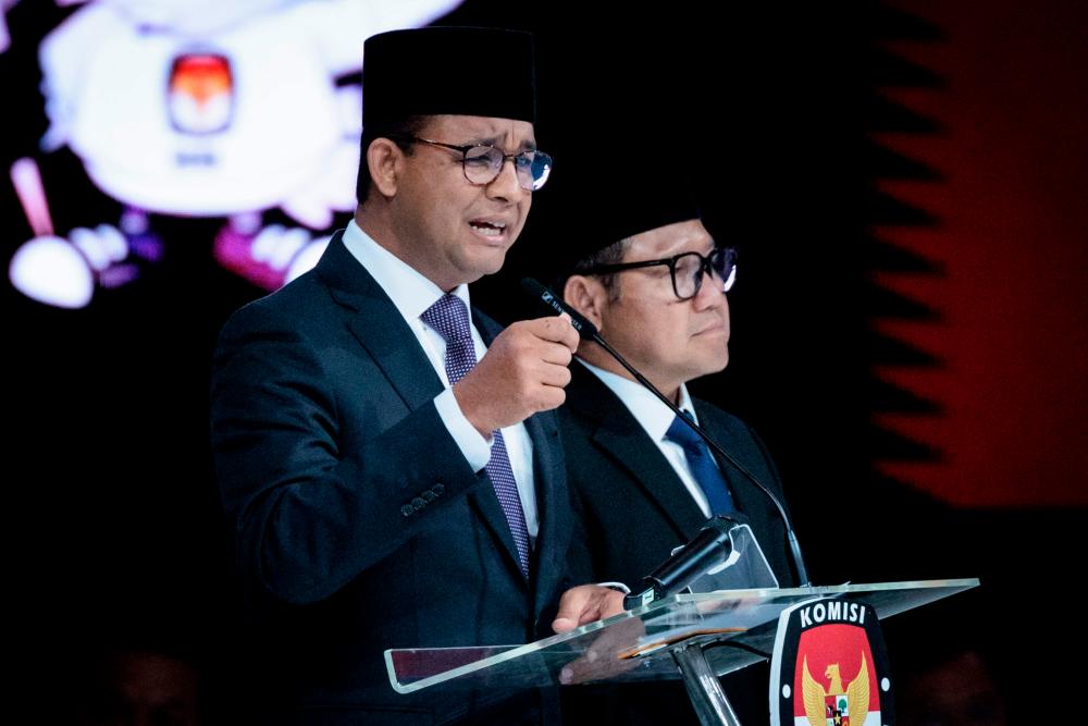 Presidential candidate and former Jakarta governor Anies Baswedan (L) speaks beside vice presidential candidate Muhaimin Iskandar during the last presidential election debate at the Jakarta Convention Center (JCC) in Jakarta. AFPPIX