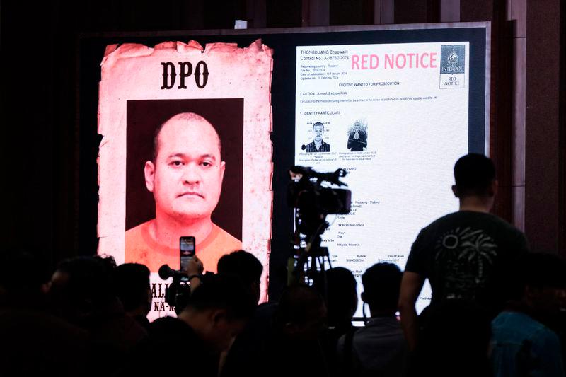 A monitor shows Thai fugitive Chaowalit Thongduang, who escaped from a hospital in Thailand while serving his sentence in 2023, during a press conference after he was arrested by Indonesian police in Bali - AFP