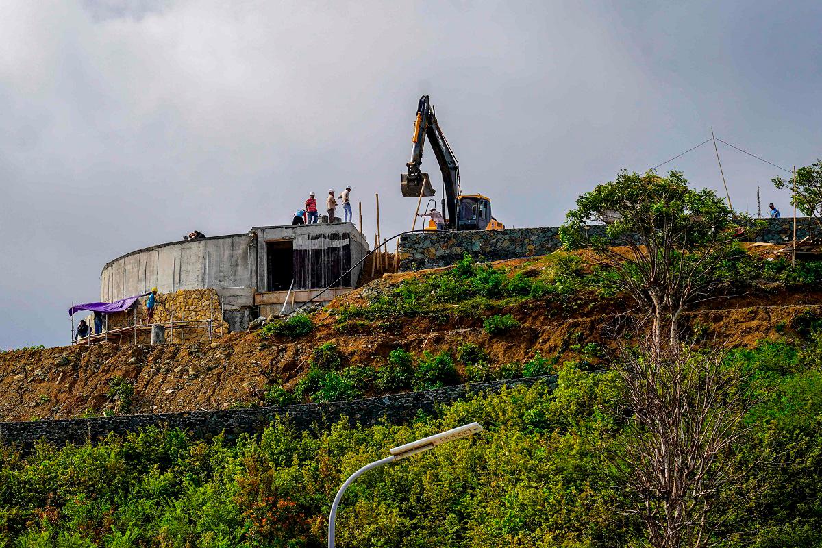 This picture taken on September 24, 2025 shows construction crew working on a hilltop, land which once belonged to villagers before it was taken over by the government to build the country’s MotoGP racing circuit, in Indonesia’s Lombok island, West Nusa Tenggara. - Jack Moore / AFP