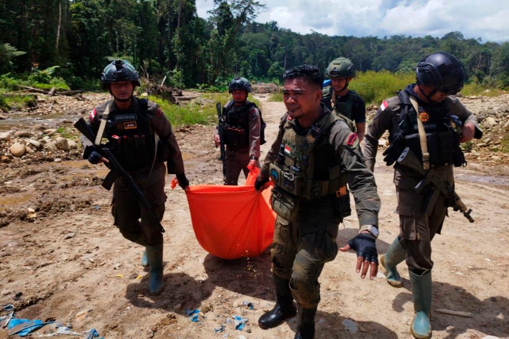 Troops retrieving the body of a victim shot by armed rebels in Seradala district, Yahukimo Regency, Papua province. Indonesian police said on October 17 that armed rebels had gunned down seven civilians when they opened fire on a gold mine in the eastern region of Papua. AFPPIX