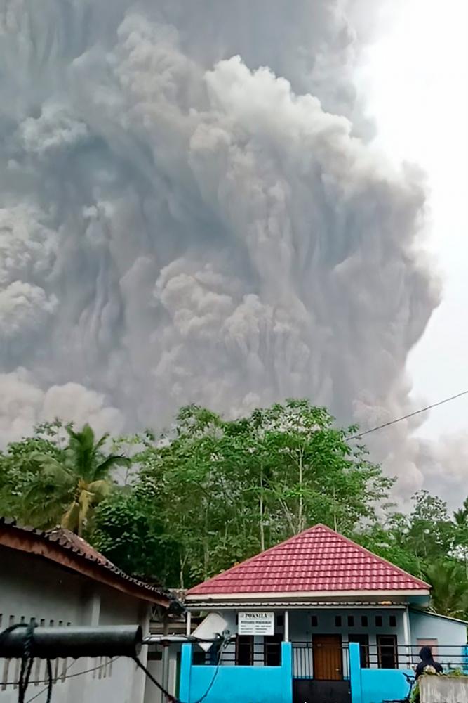 This handout picture taken and released on December 4, 2021 by Indonesia's National Board for Disaster Management (BNPB) shows Semeru volcano spewing ash into the air during an eruption as seen from Lumajang. AFPpix