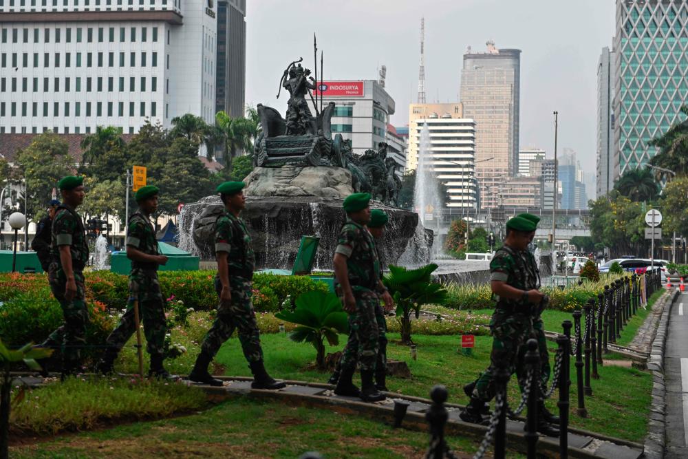 Indonesian soldiers patrol near the constitutional court in Jakarta on June 14, 2019, as the court hears a defeated presidential challenger's claim that Indonesia's 2019 election was rigged, allegations that spawned deadly rioting last month. - AFP
