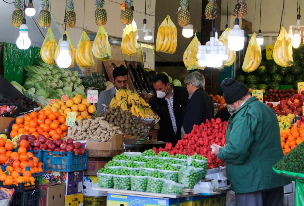 Iranians buy fruits at a market in the capital Tehran, during the novel coronavirus pandemic crisis, on April 5, 2020. - AFP