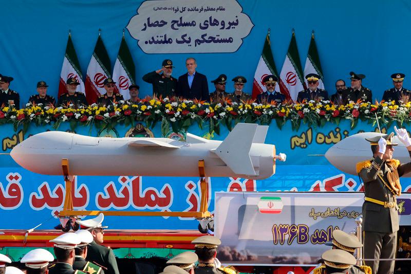 Iranian President Masoud Pezeshkian (R) and commander of the Islamic Revolutionary Guard Corps' Aerospace Force Amir Ali Hajizadeh look on as Iran's new Shahed 136-B drone is displayed during the annual military parade marking the anniversary of the outbreak of the 1980-1988 war with Saddam Hussein's Iraq, in Tehran on September 21, 2024. - ATTA KENARE / AFP)