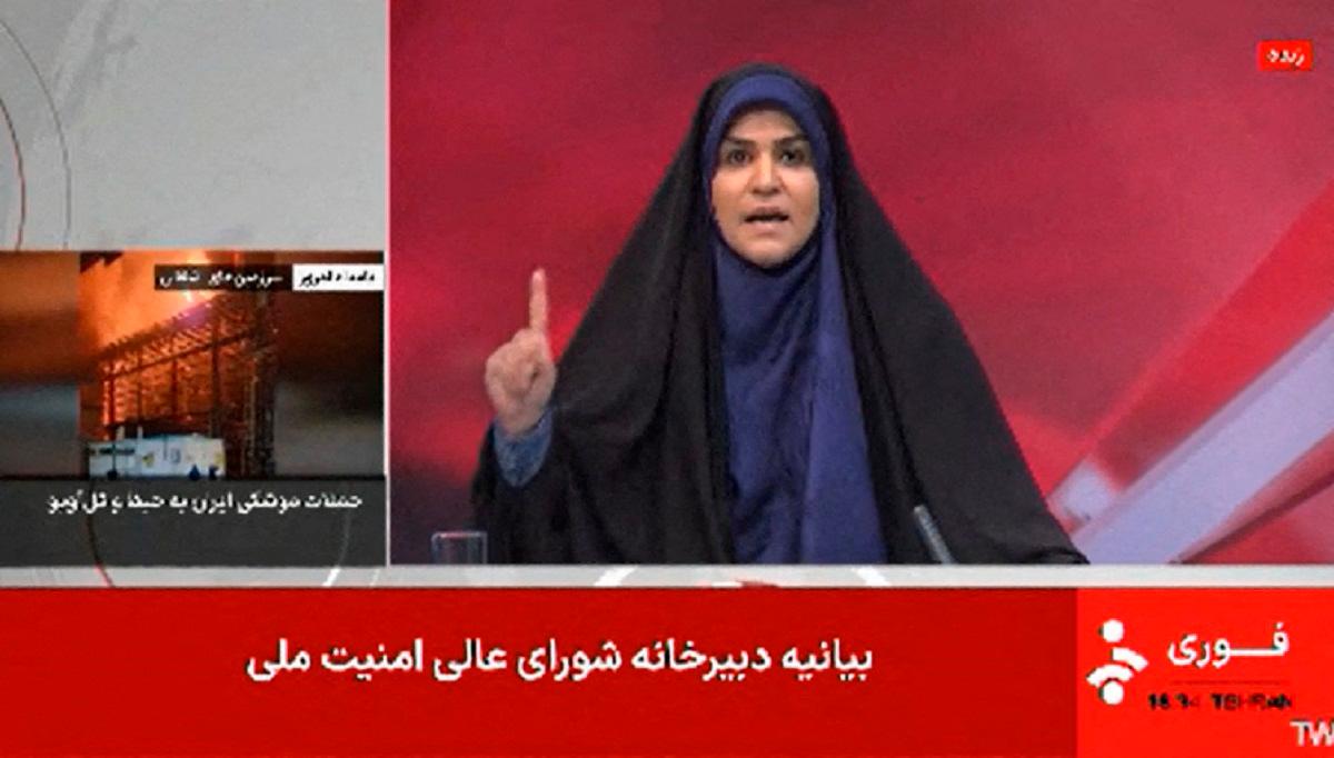 This image grab taken from footage broadcast by Iran’s IRINN news on June 16, 2025, shows a news reporter gesturing as she presents the news seconds before a loud explosion. The Islamic Republic of Iran Broadcasting (IRIB) building was struck in an Israeli attack on June 16, cutting live coverage immediately. The blast occurred as the presenter was live on TV lambasting Israel before she was seen leaving the live broadcast, Iranian media reported, sharing a video of the incident. - AFP PHOTO / IRINN