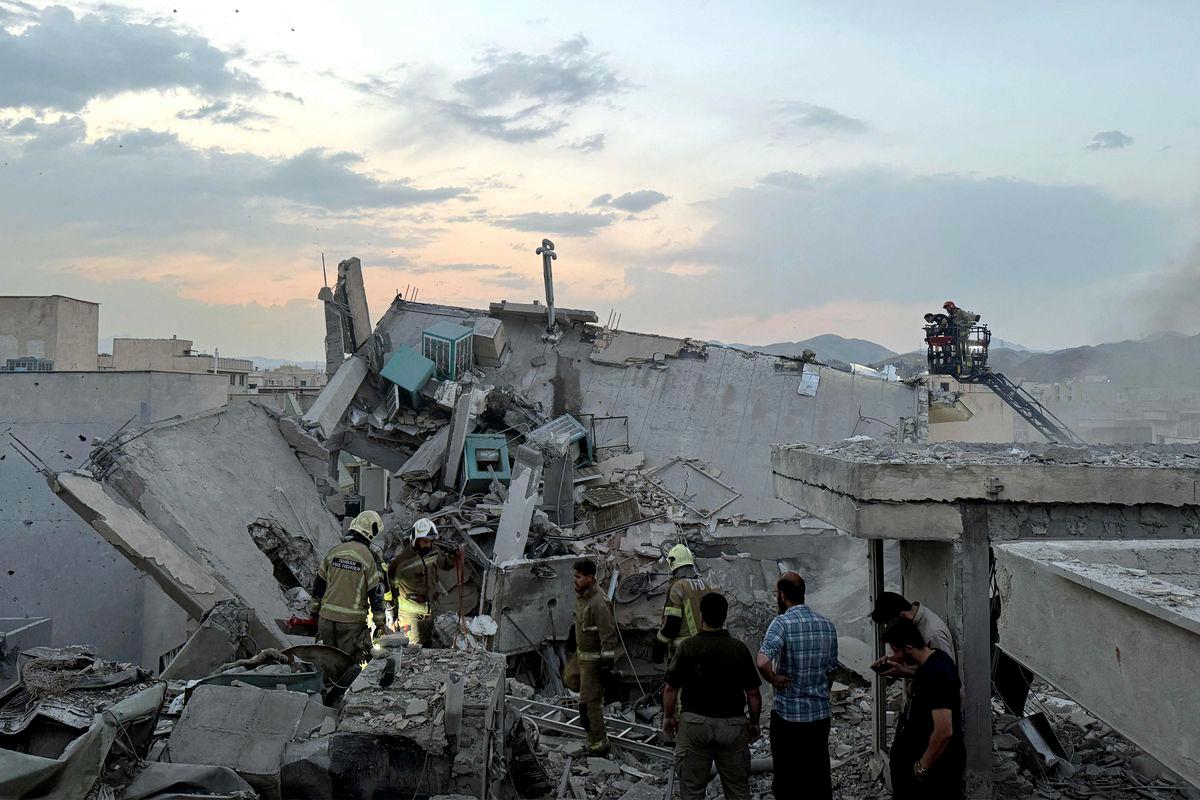 People and first-responders gather atop a building a that was hit by an Israeli strike in Tehran on June 13, 2025. - AFPPIX