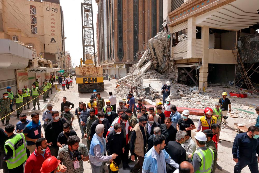 A handout picture provided by the Iranian presidency shows Iranian vice president Mohammad Mokhber (C) visiting the site where a ten-storey building collapsed in the southwestern city of Abadan on May 27, 2022. AFPPIX