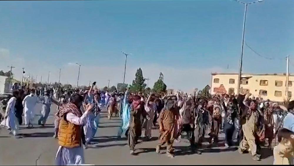 This image grab from a UGC video posted on November 11, 2022, shows protesters holding signs and chanting slogans during a march in Khash, in Iran's southeastern province of Sistan-Baluchistan. AFPPIX