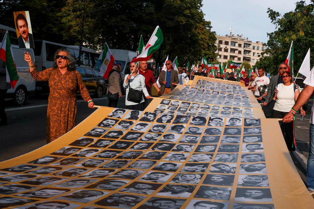 People hold a placard with pictures of, as Iranian call them, martyrs, during a rally of Iranian diaspora in Europe, on the eve of the first anniversary of the death of Mahsa Amini, which prompted protests across their country, in Brussels, Belgium September 15, 2023. REUTERSPIX