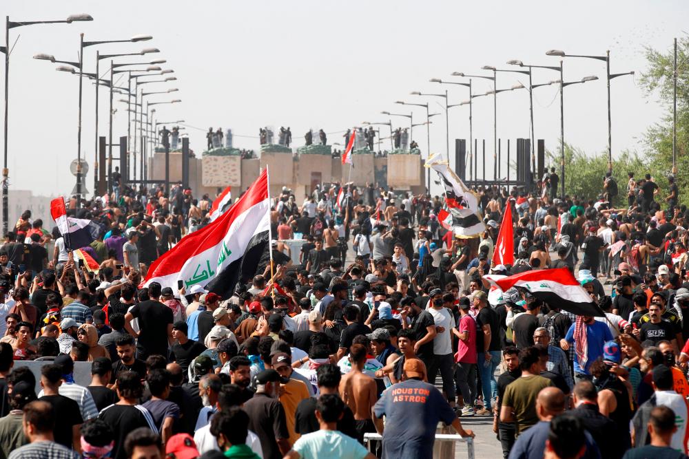 Iraqi anti-government demonstrators wave the national flag as they attend a protest in Tahrir Square in the centre of Iraq’s capital Baghdad on October 1, 2022. AFPPIX