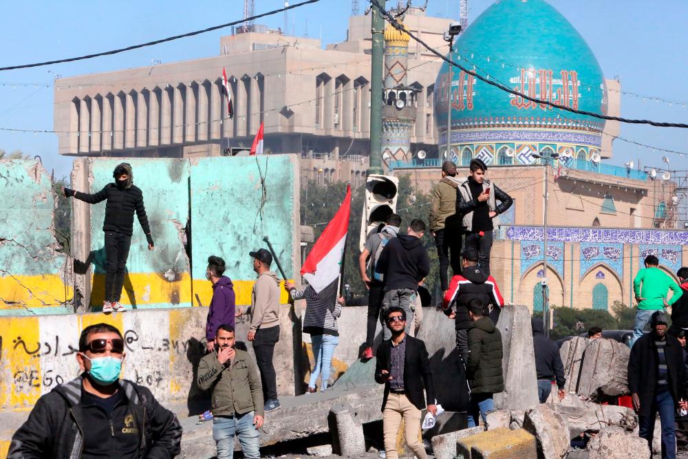 Iraqi anti-government protesteters clash with security forces in al-Khillani Square off central Baghdad's Sinak bridge which links the Iraqi capital's Green Zone with the rest of the city on January 27, 2020. - AFP