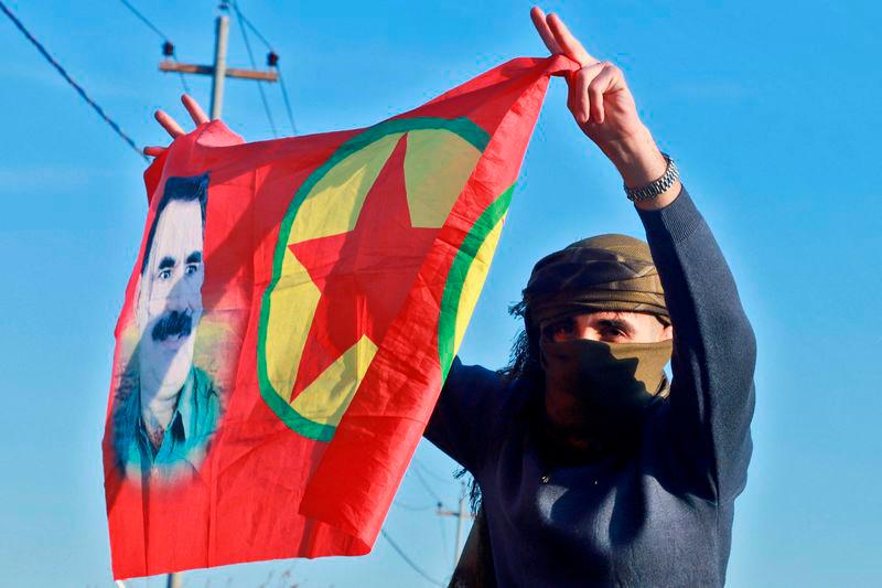 An Iraqi Kurdish woman waves a flag bearing the portrait of the founder of the Kurdistan Worker’s Party (PKK) Abdullah Ocalan as people gather at Freedom Park to listen to an audio message by the jailed leader in Sulaimaniyah, in Iraq’s autonomous Kurdistan reigion - AFPpix