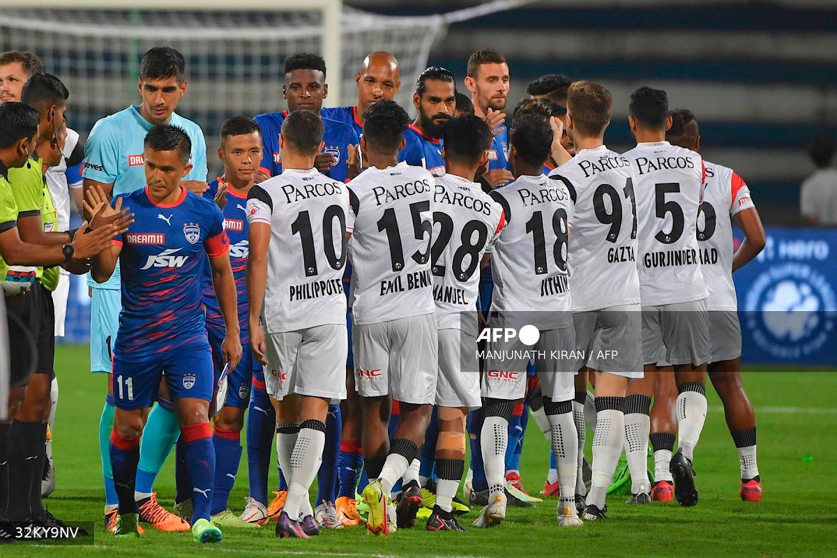 Players of Bengaluru Football Club and North East United Football Club greet each other before the commencement of the Indian Super League (ISL) 2022-23 football tournament, between Bengaluru Football Club and North East United Football Club played at the Shri Kanteerava Stadium in Bangalore on October 8, 2022. - MANJUNATH KIRAN / AFP