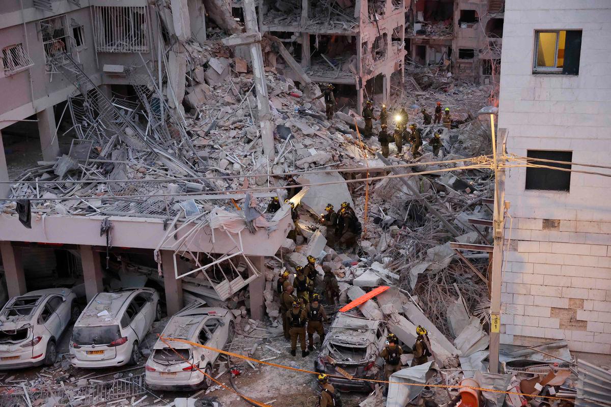 Responders work amid building rubble following a strike by an Iranian missile in the Israeli city of Bat Yam, south of Tel Aviv, early on June 15, 2025. Air raid sirens and booms rang out in Jerusalem and Tel Aviv early on June 15, AFP journalists said, as Israel and Iran exchanged fire for a third day. AFPpix