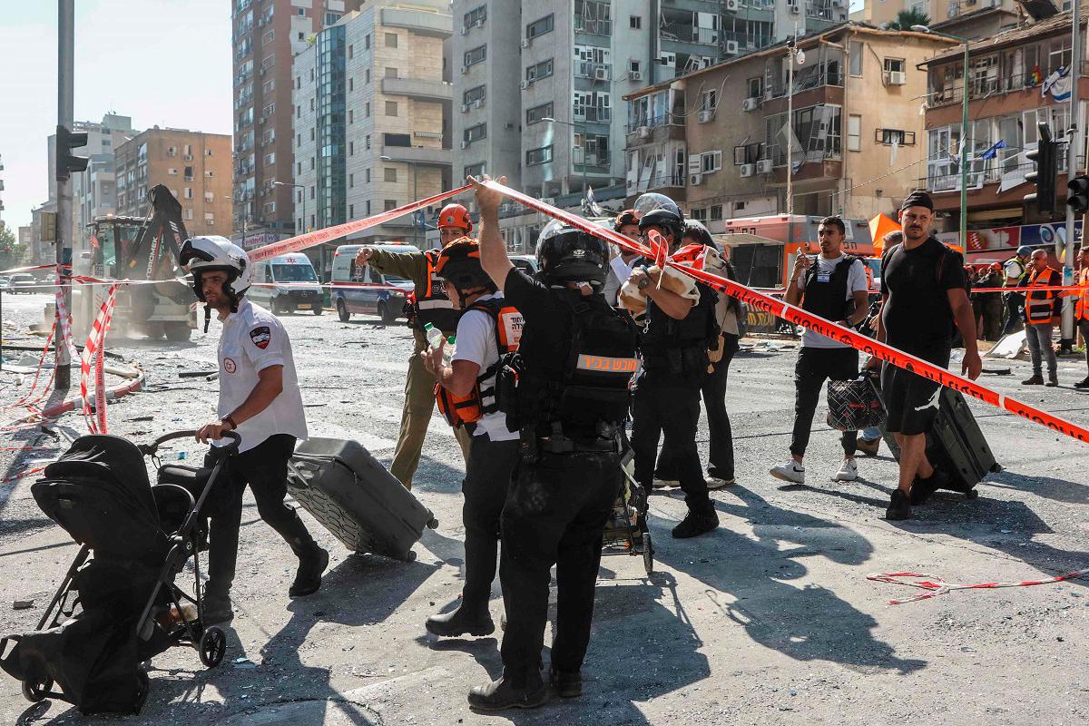 Israeli emergency services help evacuate civilians from the site of an Iranian missile attack in Ramat Gan in central Israel near Tel Aviv, on June 19, 2025. - GIL COHEN-MAGEN