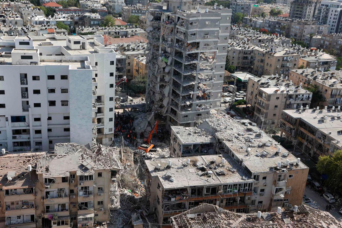 Israeli rescuers search through the rubble at the site of an overnight Iranian missile strike in Bat Yam on June 15, 2025. (Photo by GIL COHEN-MAGEN / AFP)
