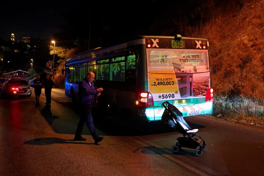 Israeli security inspect a bus after an attack outside Jerusalem's Old City, August 14, 2022. Seven people were injured, two of them critically, after a shooting attack on a bus in Jerusalem's Old City, Israeli police and the national emergency medical services said early August 14, 2022. - AFPPIX